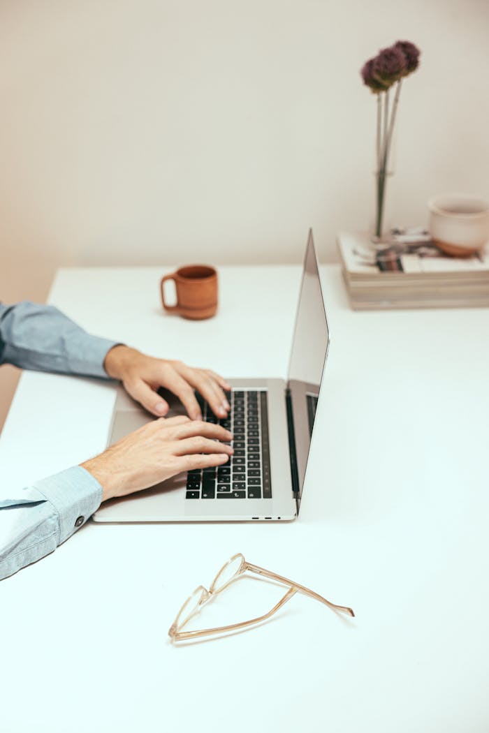 gallery-3 Hands typing on a laptop at a minimalist desk, ideal for remote work or digital nomad lifestyle.